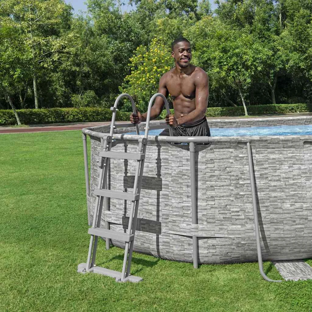 Piscine tubulaire ovale 488 x 305 x 107 cm effet pierre avec hublots et pompe – vue en situation